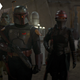 Boba Fett, flanked by Fennec Shand and two Gamorrean Guards, patrol the streets of Tatooine at night.
